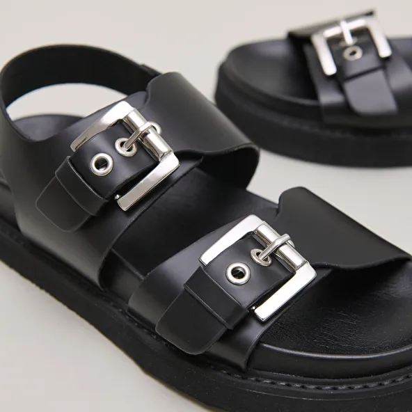 Double buckle sandals in glazed black leather